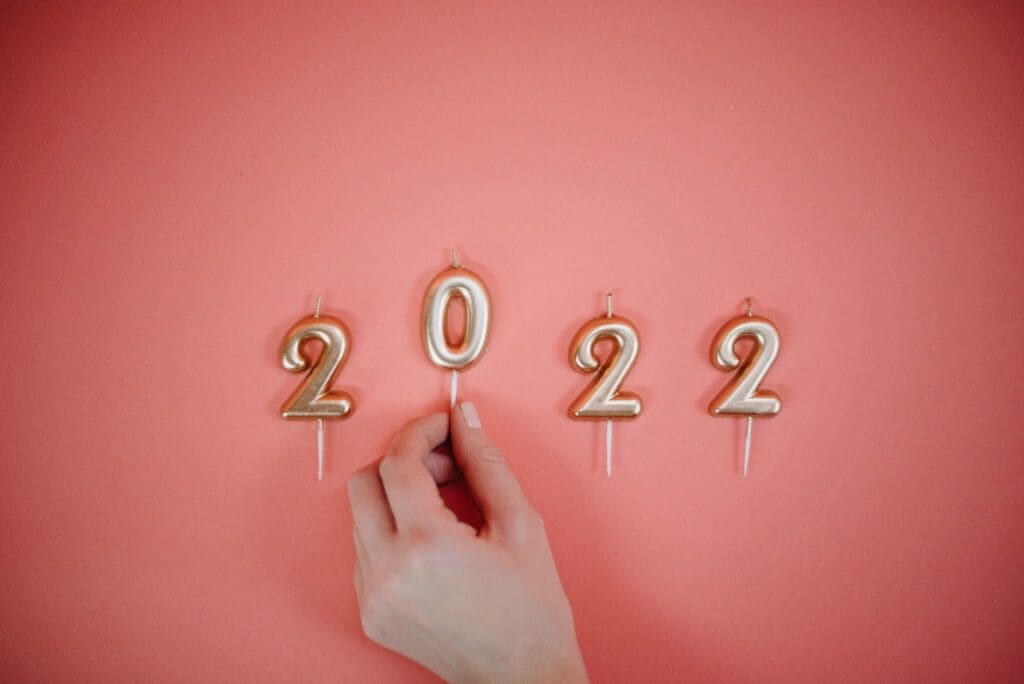 A hand holding candles in the shape of 2022